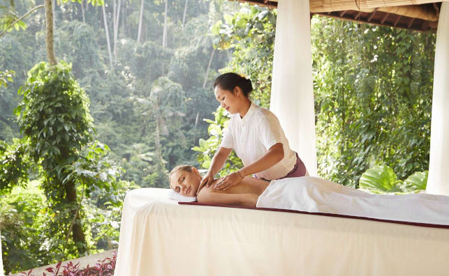 chica en camilla recibiendo un masaje con vistas a paisaje de selva indonesia 